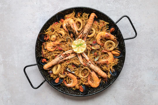 Паэлья - блюдо из риса, морепродуктов или мяса, овощей и шафрана.